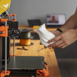 PLA filament tekercs egy 3D nyomtató mellett